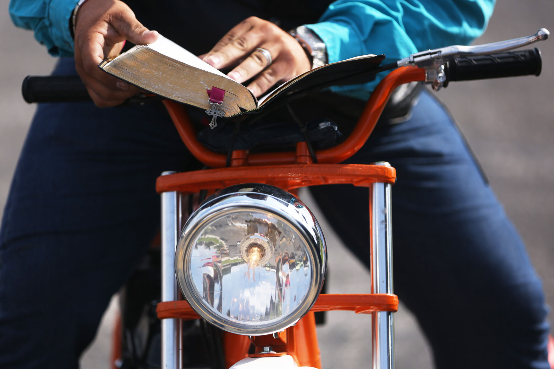 Colton Gonka, Casper, thumbs through a bible from atop the bike
